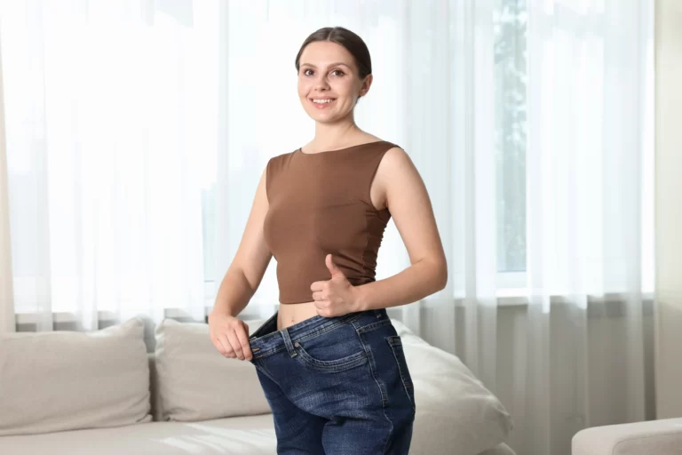 beautiful woman wearing old jeans after weight los utc