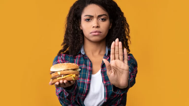 black woman holding burger and showing stop gestur utc