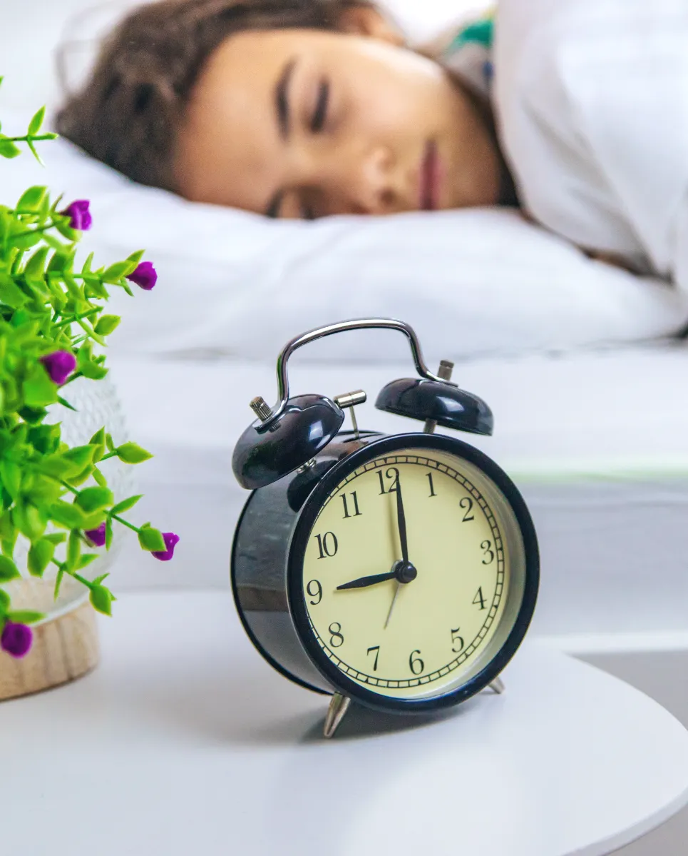 child asleep near alarm clock in bedroom utc