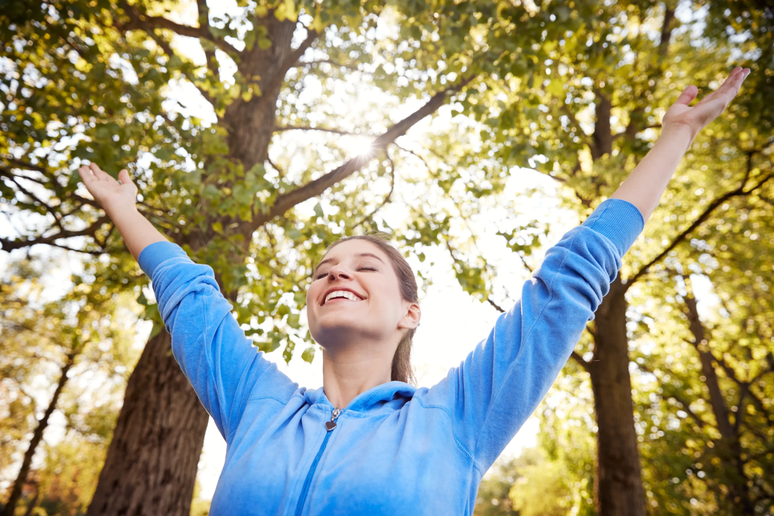 woman outdoors in fitness clothing stretching arms utc