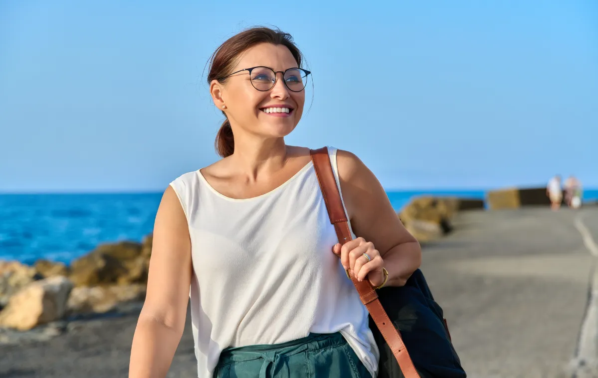 beautiful mature woman with backpack walking outdo utc