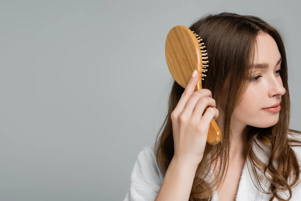 pretty young woman in bathrobe brushing shiny and utc