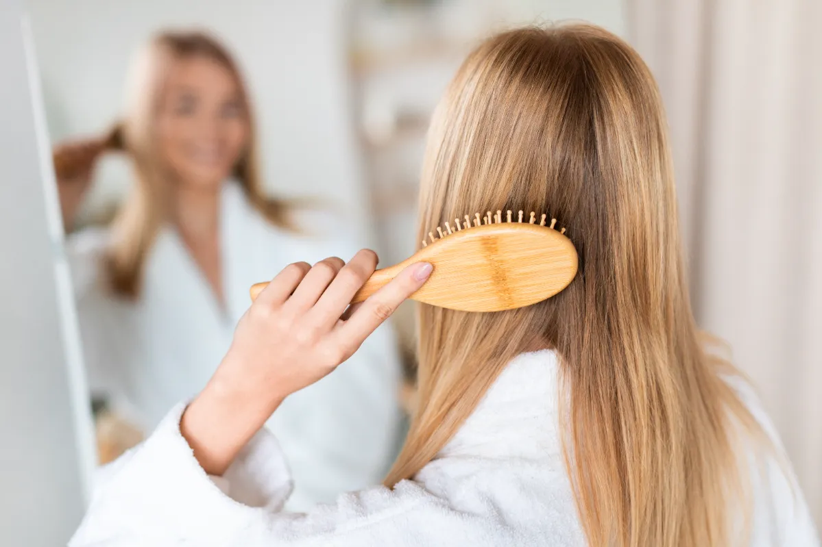 rear view of lady combing hair near mirror in bath utc