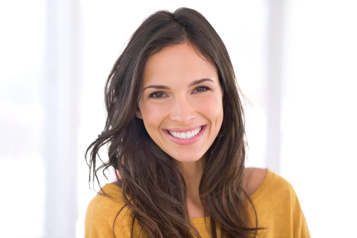 smiling woman in studio wearing yellow top utc