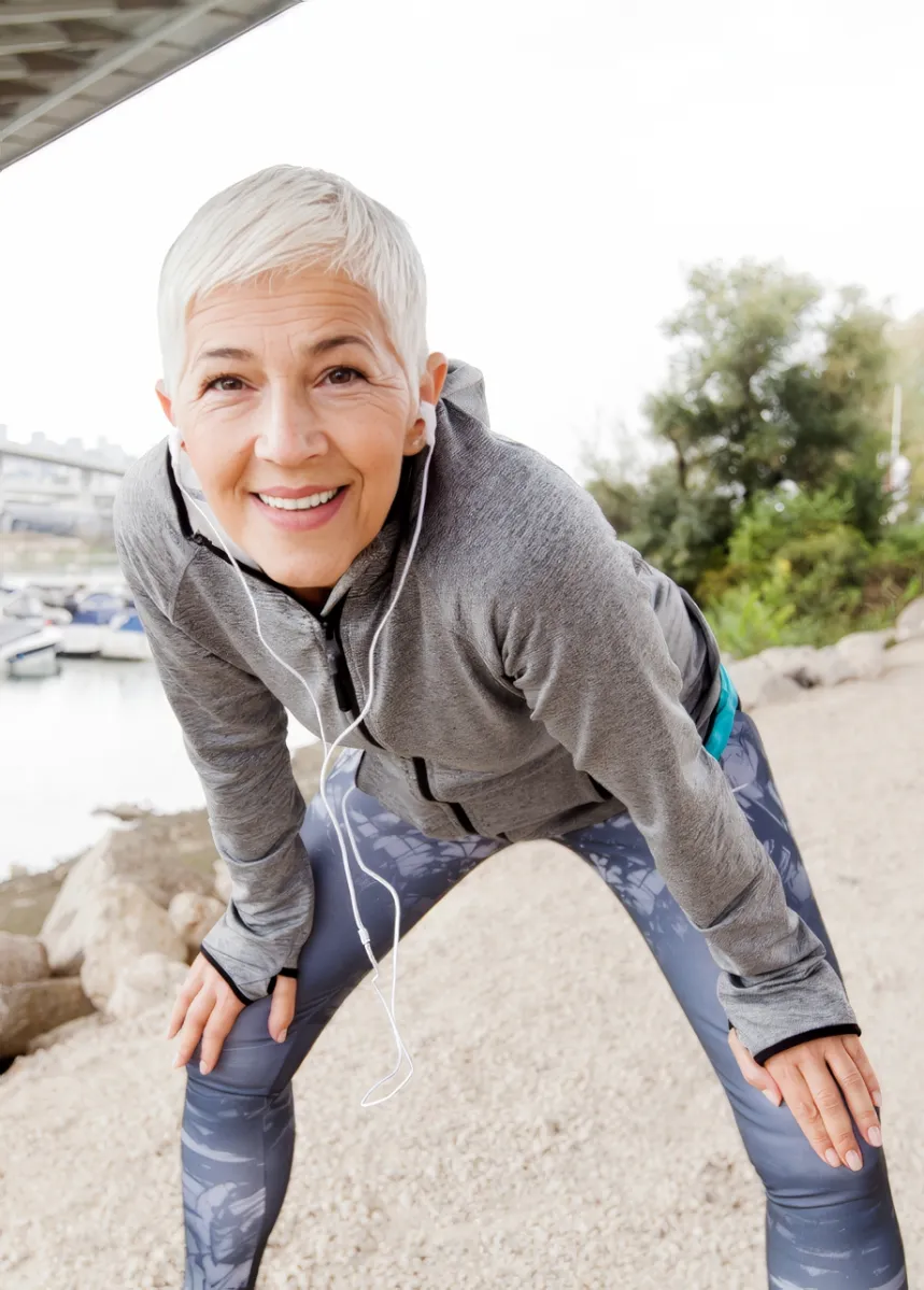 smiling woman stretching near water underneath bri utc