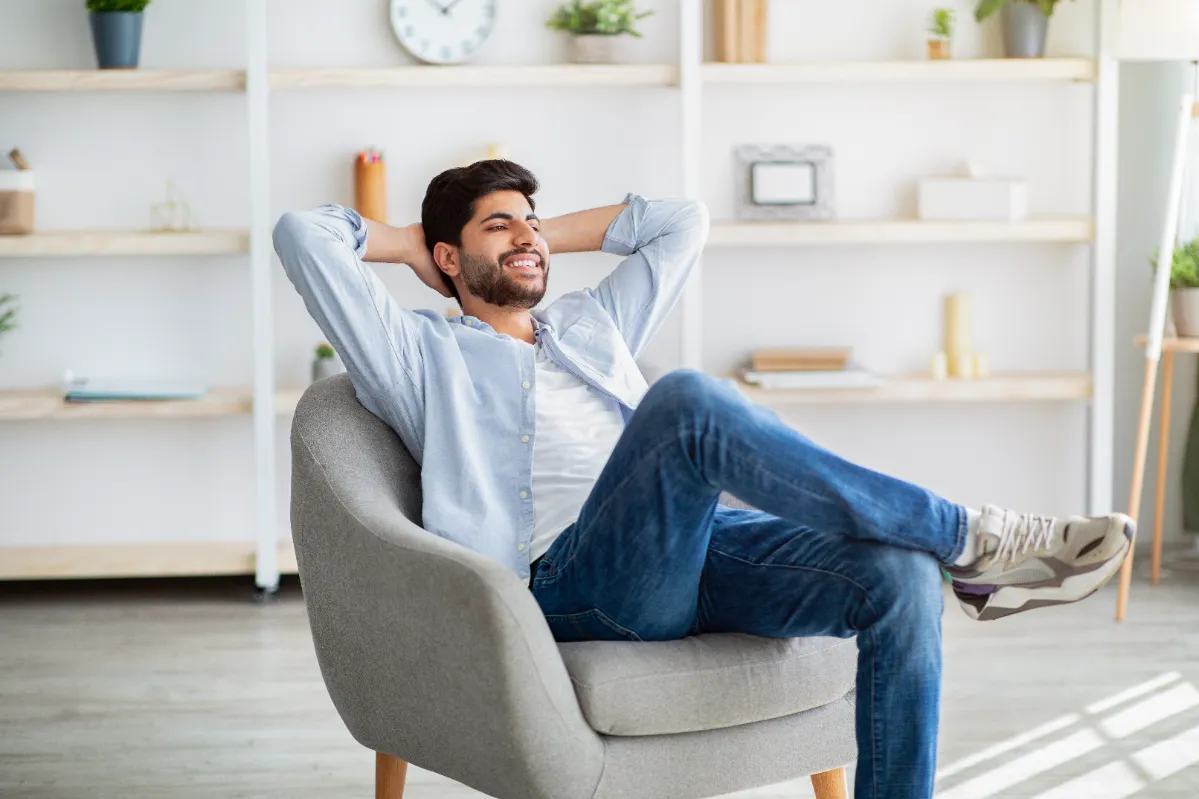 young man relaxing in armchair at home utc